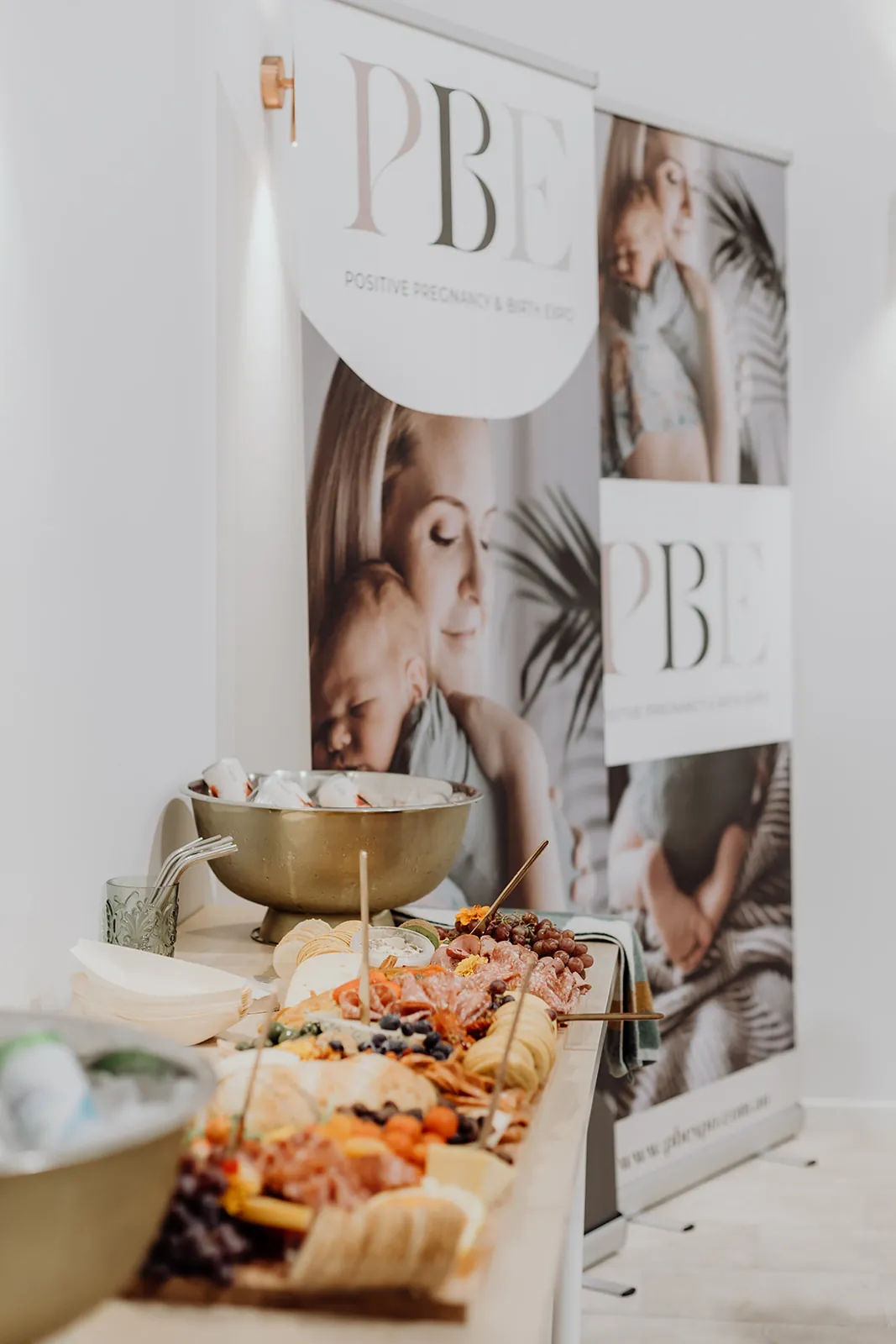 A grazing table beside event banners at Birdcage Studios