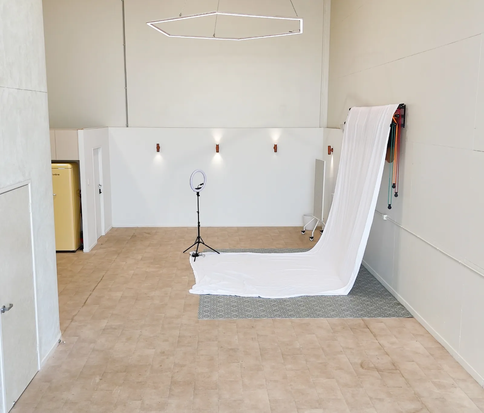 The whole studio at Birdcage Studios, with the white sweep, wall lights and kitchenette