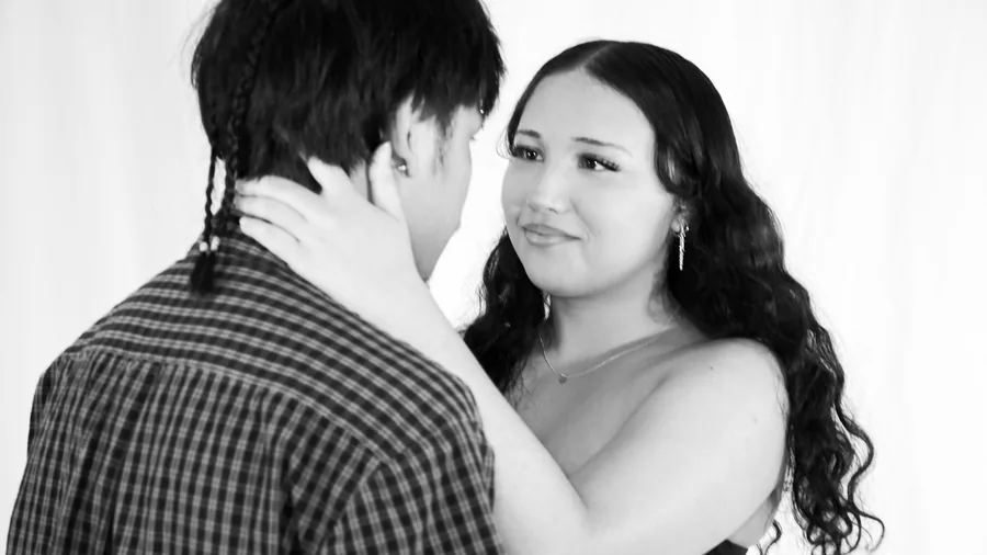 A couple photographed close together on the white sweep at Birdcage Studios